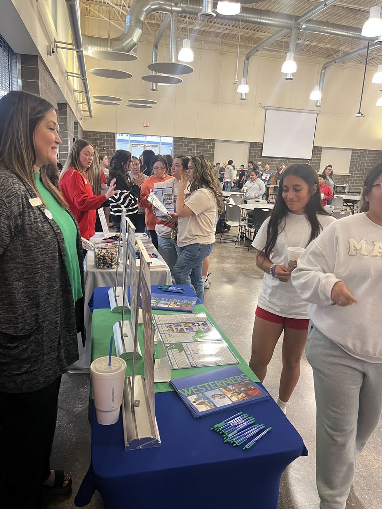 Students meet with staff at information table.