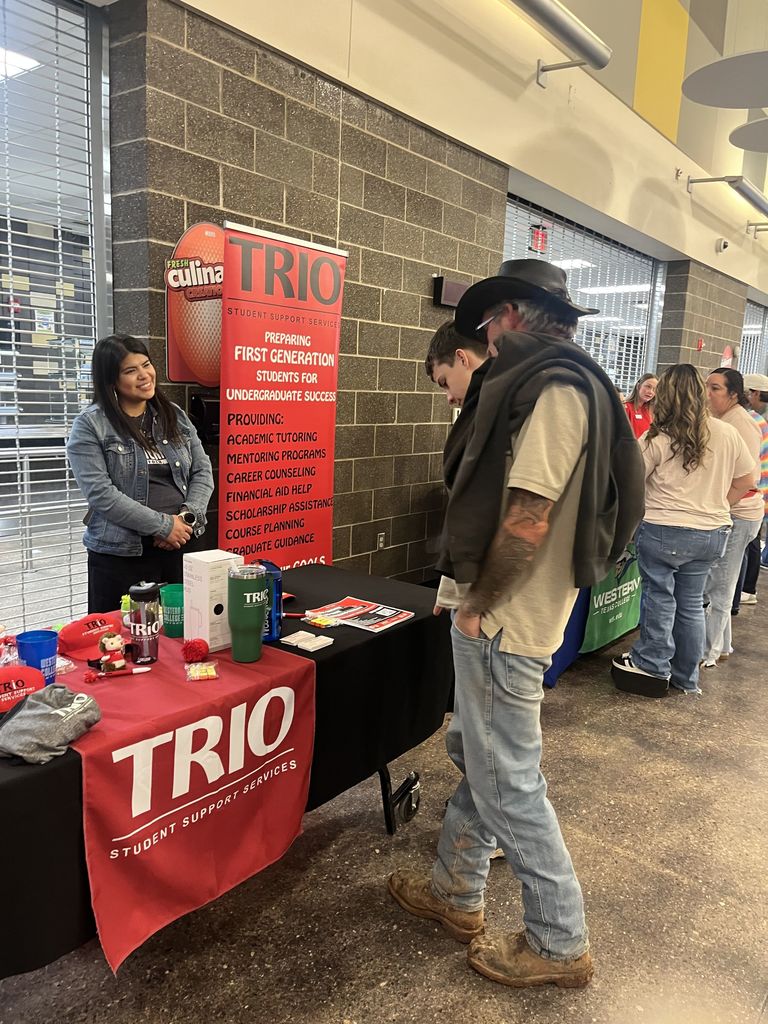 Students gather at campus resource table with brochures and giveaways.