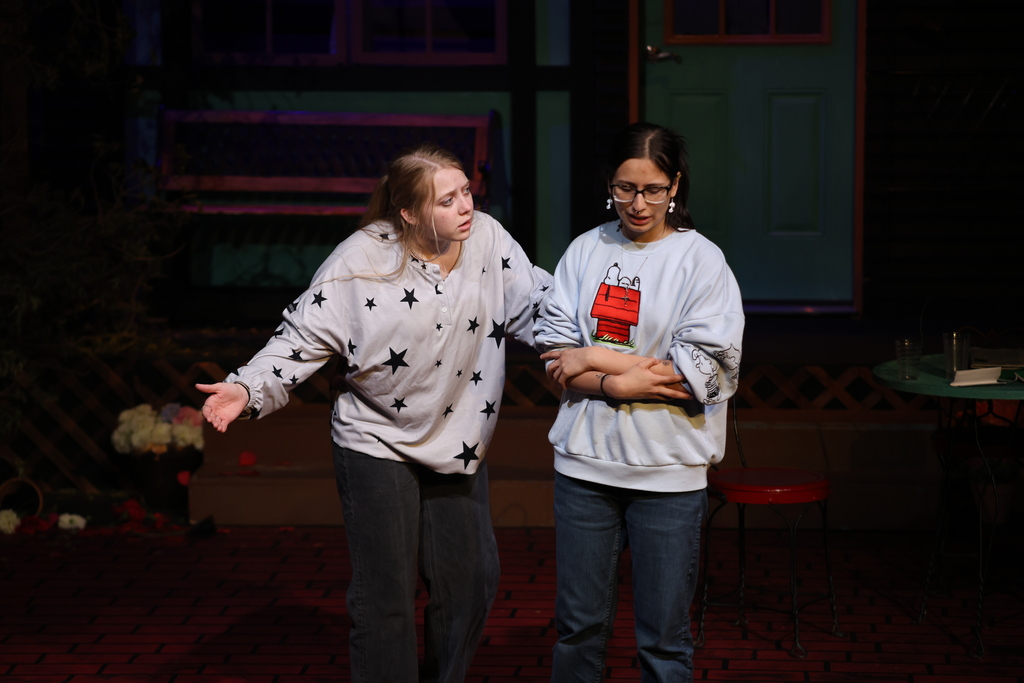 Two student actors perform dialogue scene during rehearsal.