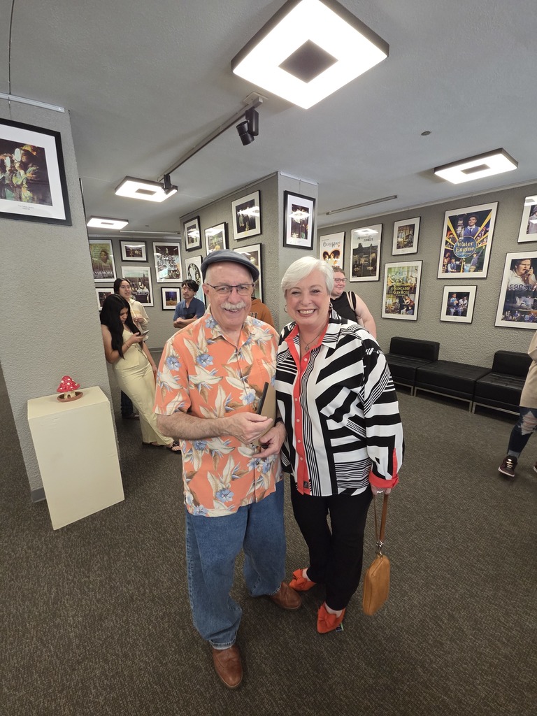 Ray and Neena pose for photo in Fine Arts lobby after campus play.
