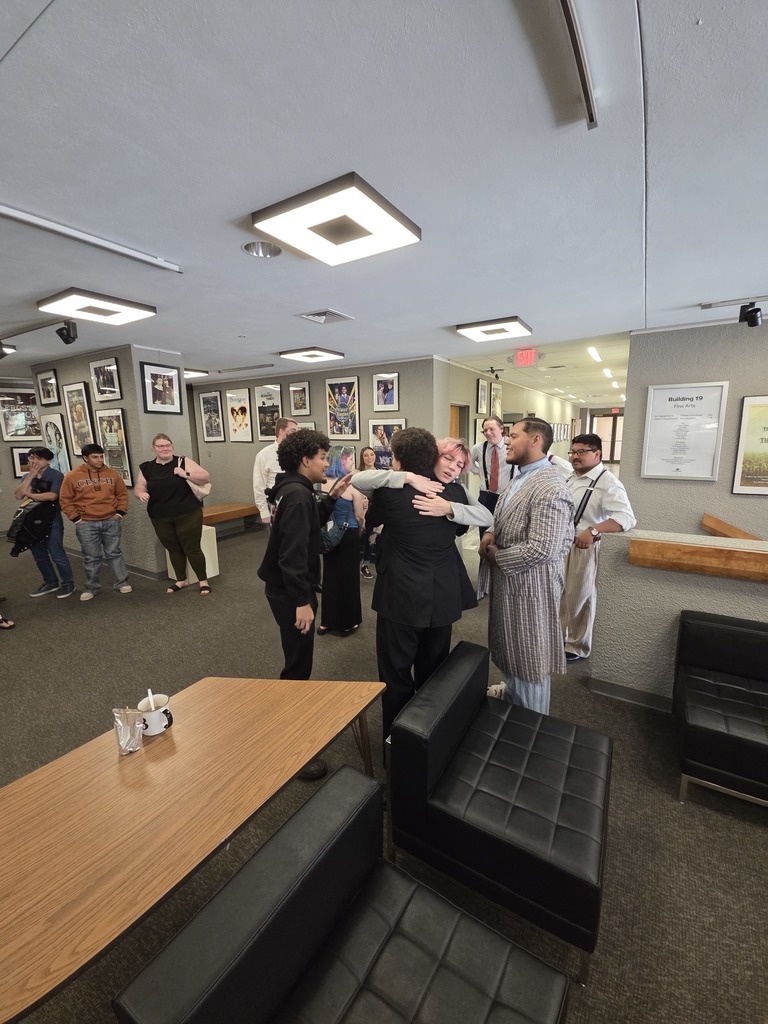 Student actors share hug with guests after campus performance.