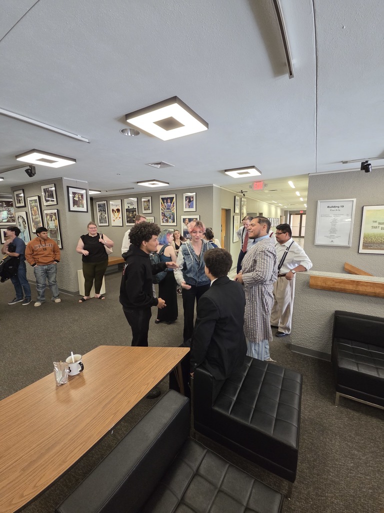 Theater cast members and guests talk in Fine Arts lobby after show.