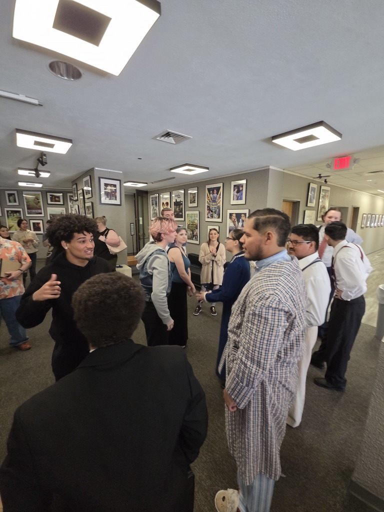 Cast members and guests mingle in theater lobby after performance.