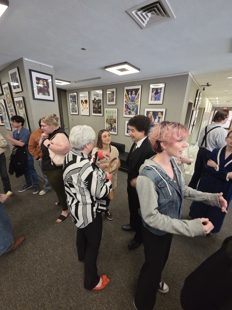 Student actors greet guests in Fine Arts lobby after performance.