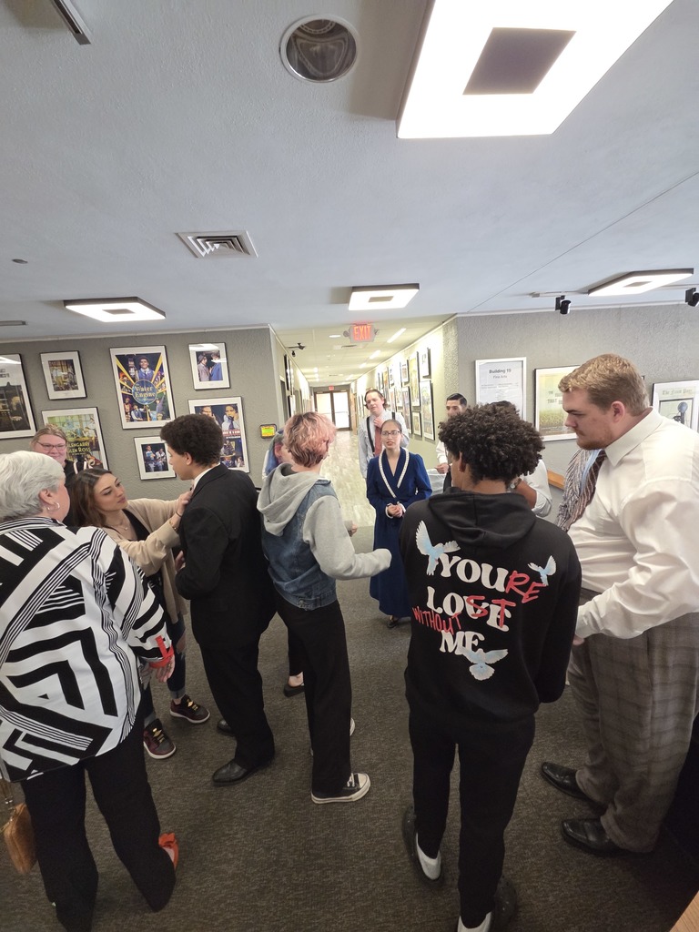 Theater cast and guests gather in Fine Arts lobby after campus performance.