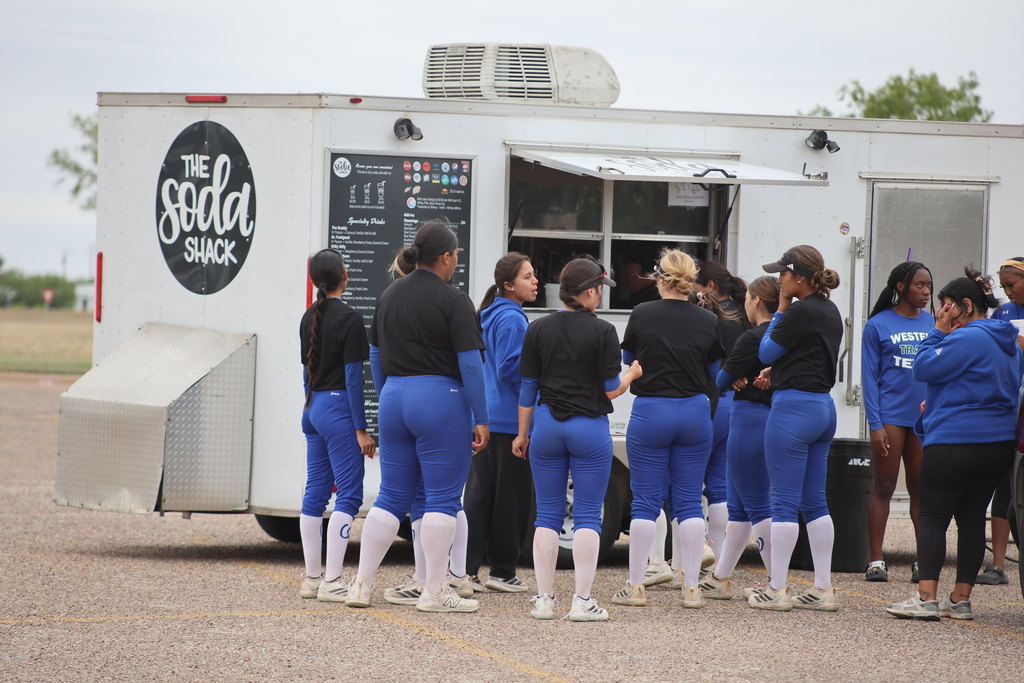 Softball team lines up at food truck during campus event.
