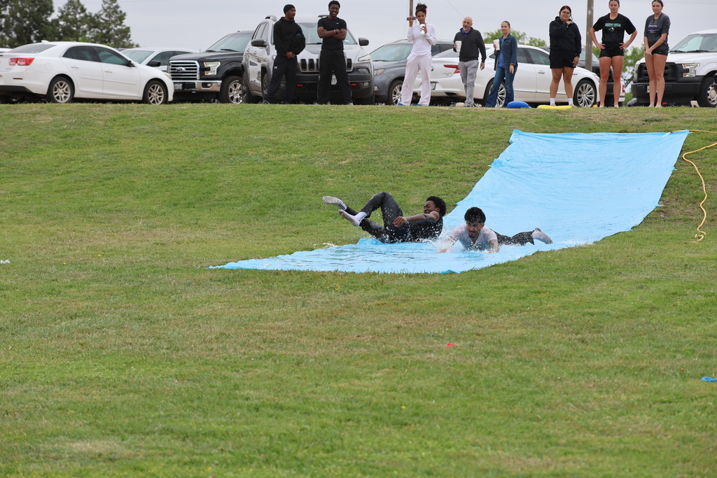 Student slides down slip-n-slide while others watch