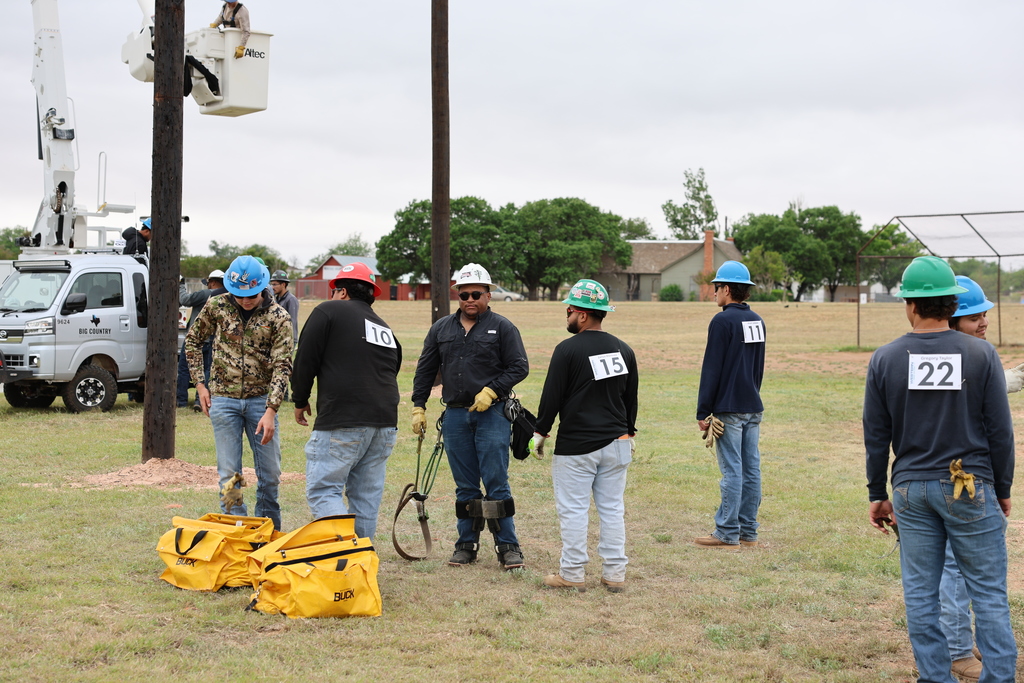Students gather near utility poles at event.