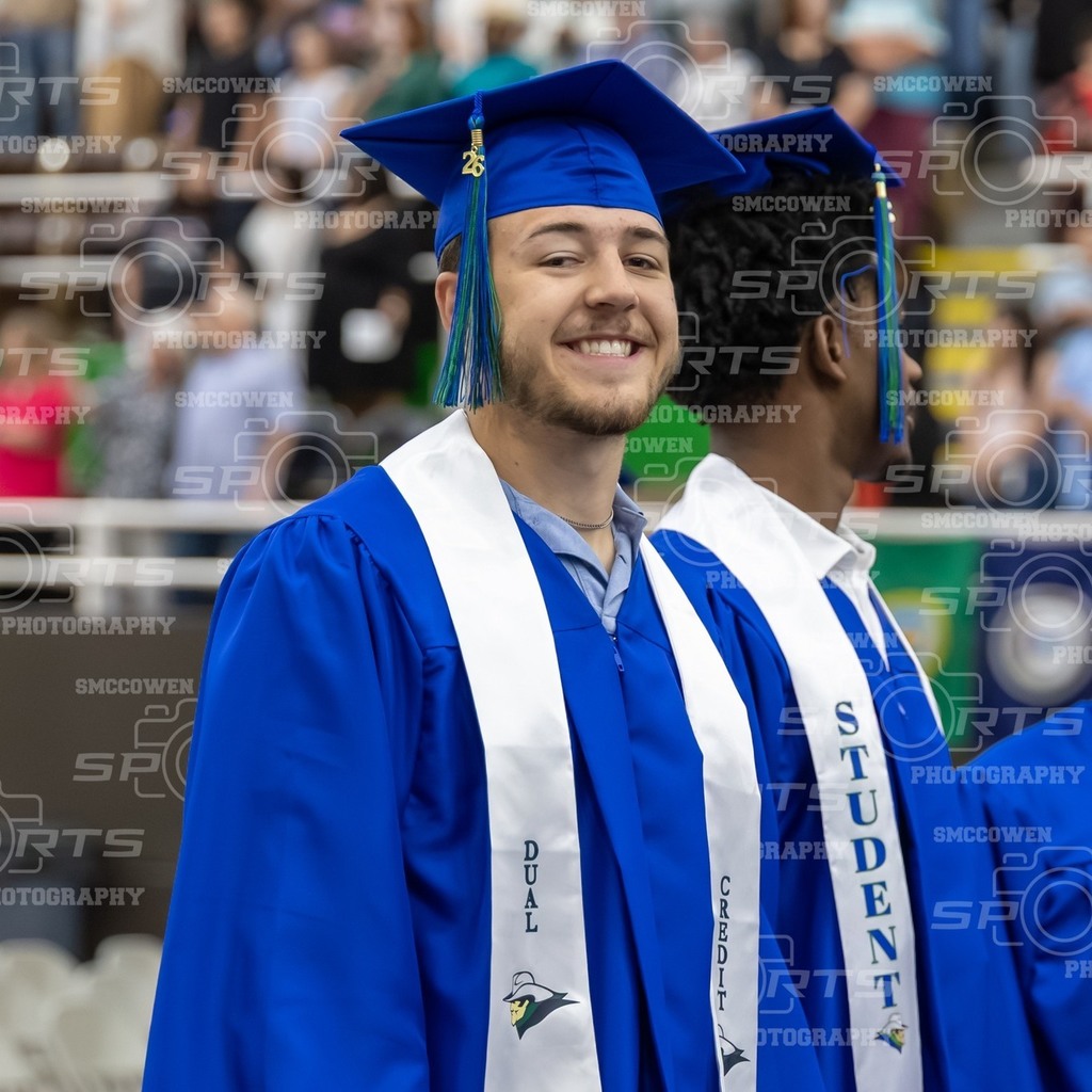 A Dual Credit graduate smiles standing next to a student.
