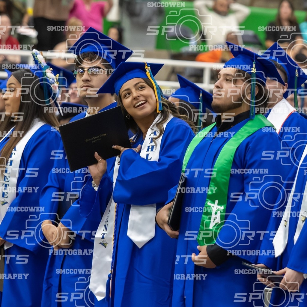Graduate smiles leaning head against diploma cover.