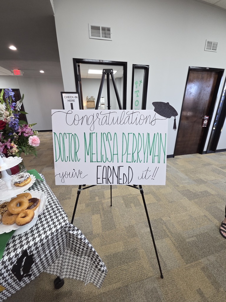 A poster on an easel reads "Congratulations Doctor Perryman - you've earned it!"