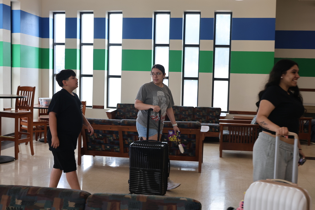 Upward Bound students arrive at Western Texas College residence hall carrying luggage and moving belongings into campus housing.