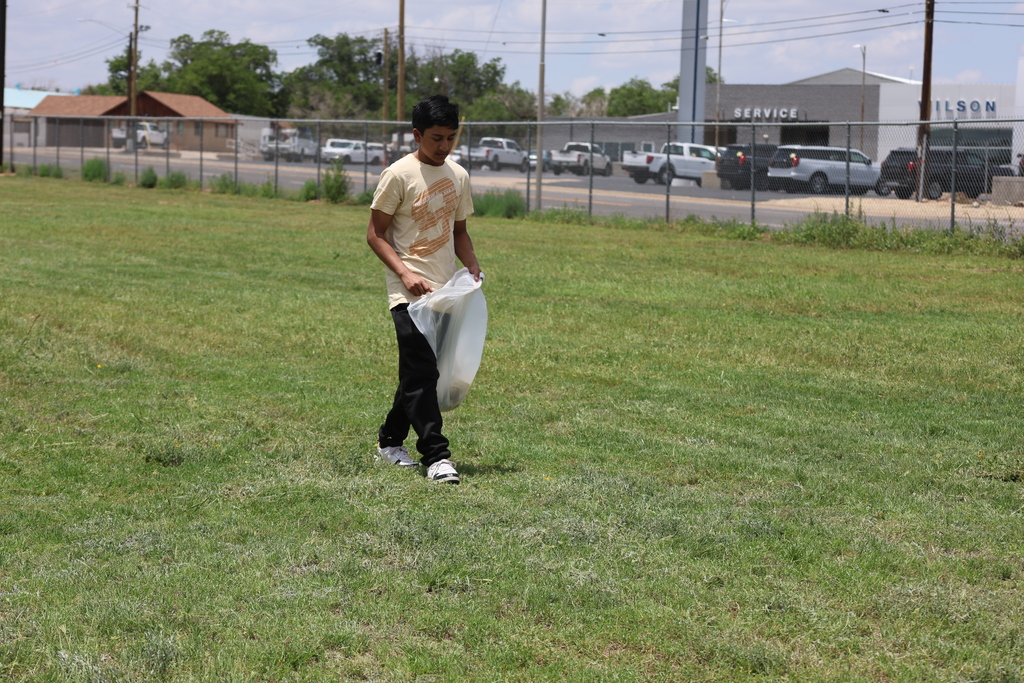 Student collects litter on campus grounds during community service activity.