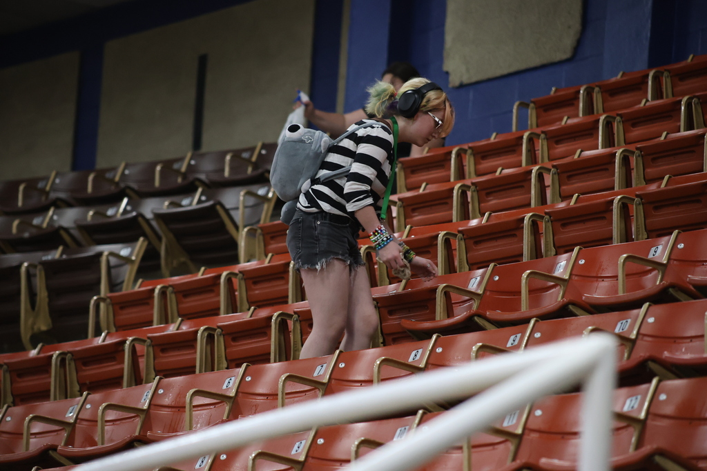 Student cleans seating area in WTC Coliseum during campus service project.