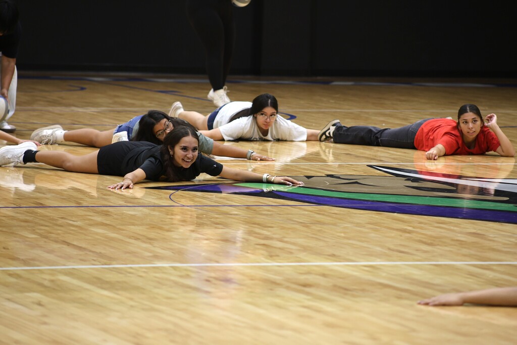 Students laying on the floor playing volleyball knockout game