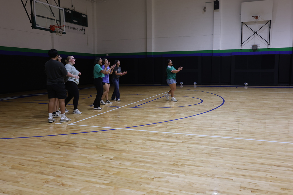 Students cheer from the sideline during a volleyball game in the WTC gym.