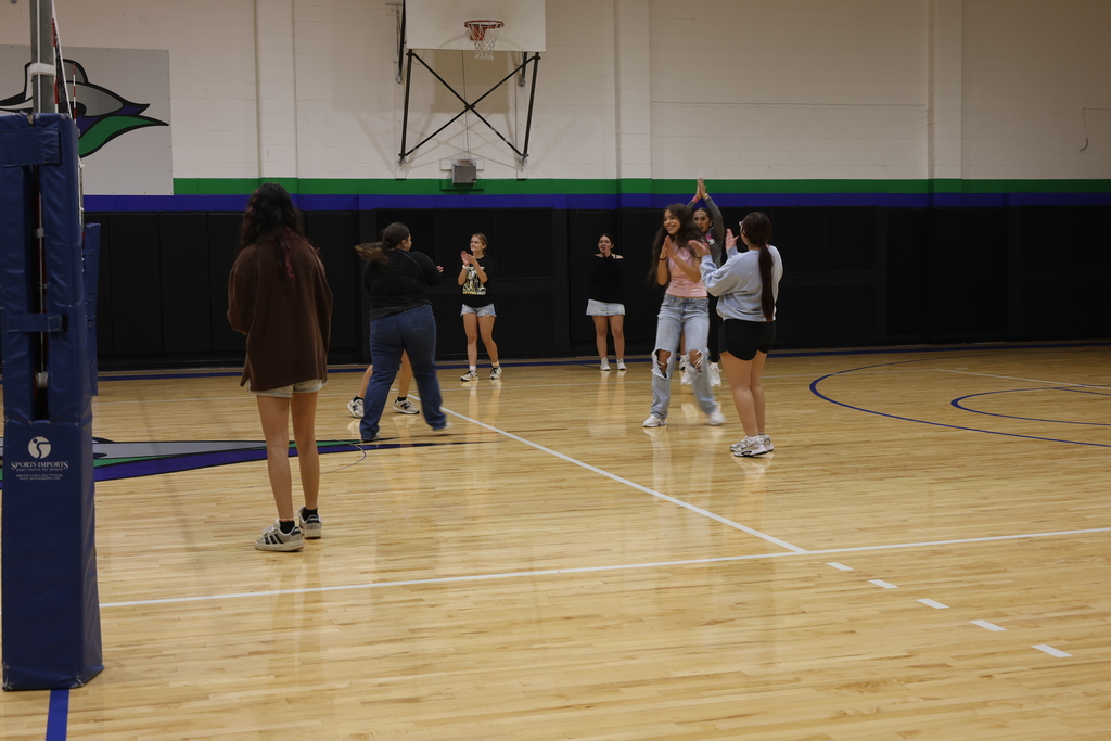 Students celebrate and applaud during a volleyball game in the WTC gym.