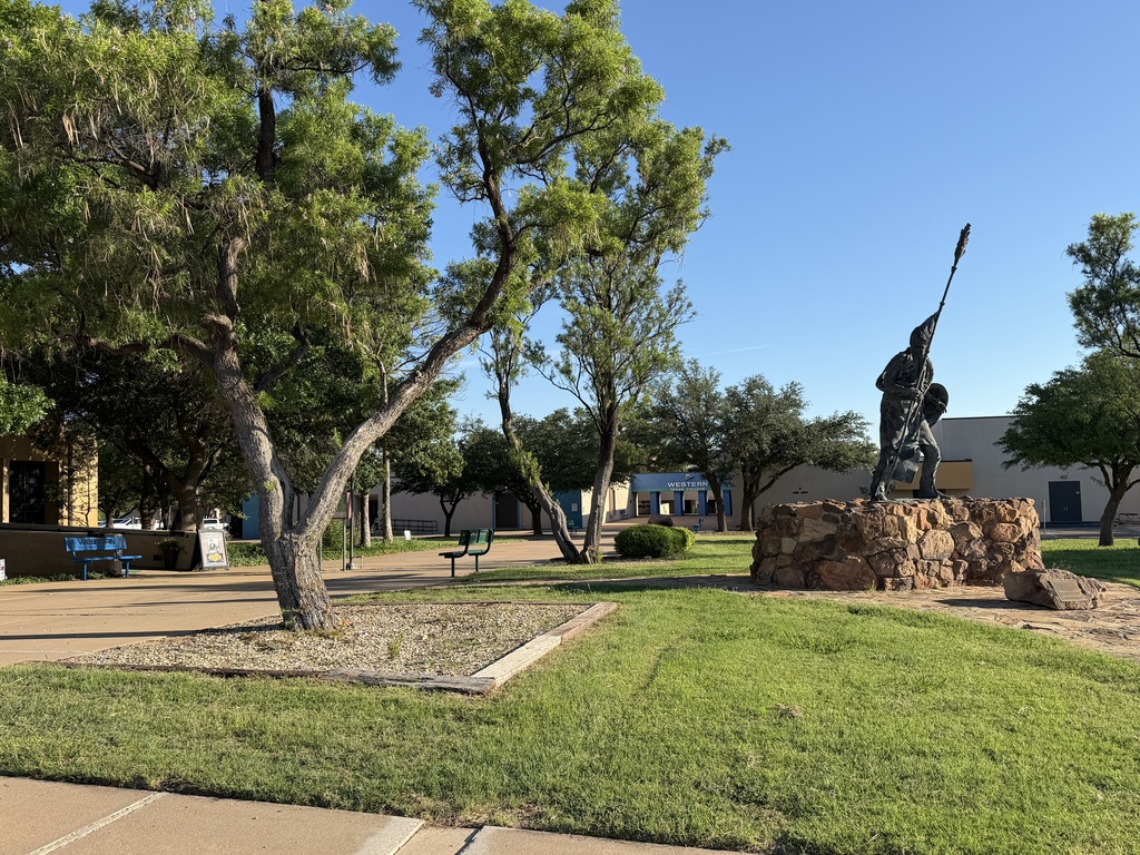 A view of the front of the campus with the Quanah Parker statue on the right and the WTC Arch in the distance.