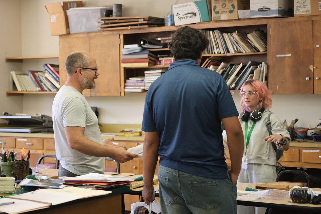 Art instructor talks with students during a classroom discussion in the WTC art studio.