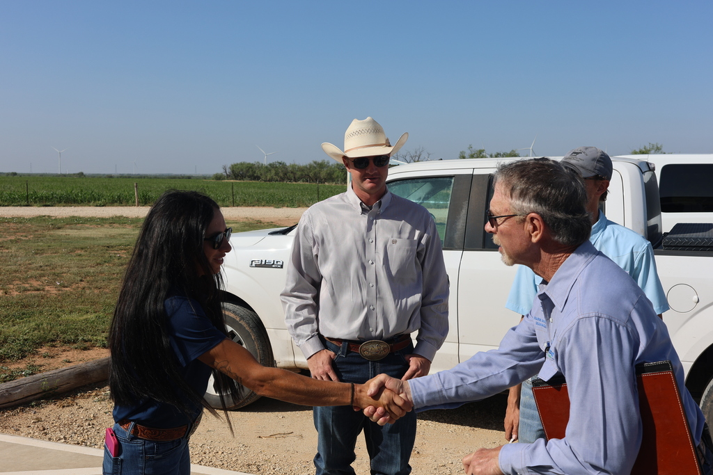 People greet each other with a handshake outside the Western Texas College Agricultural & Rodeo Complex.