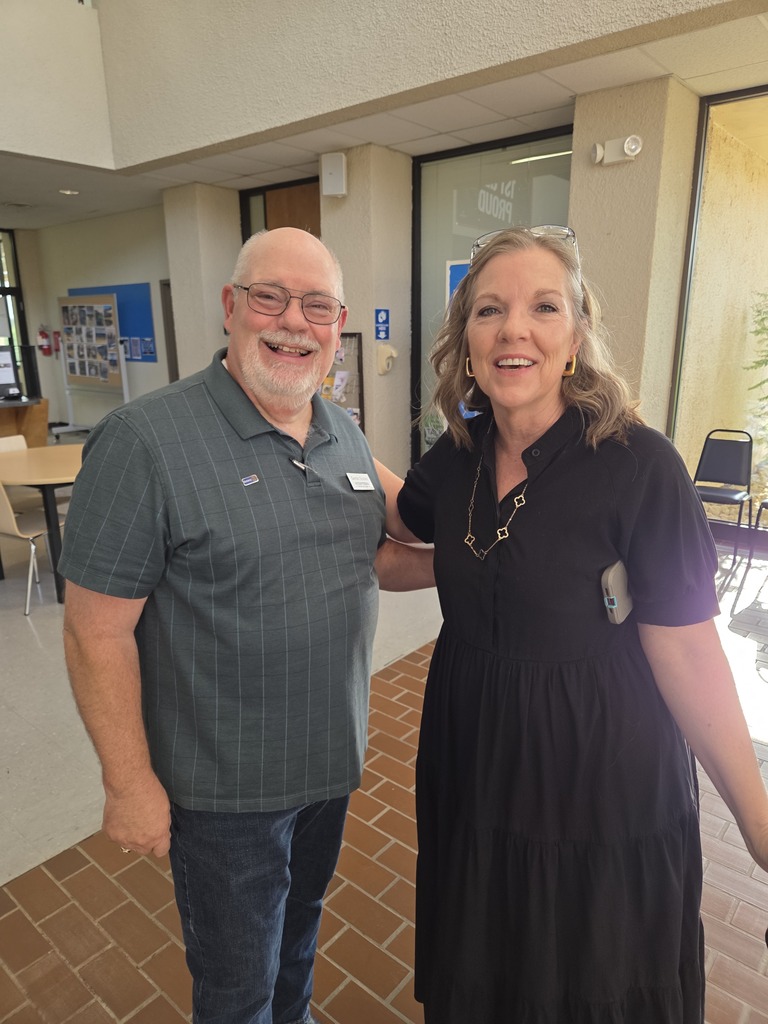 Two Western Texas College employees smile together in the campus lobby during Welcome Back activities.