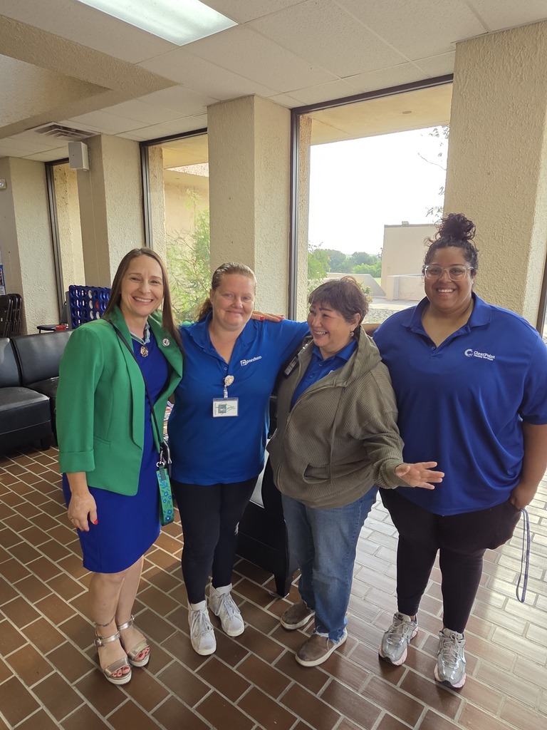 Four Western Texas College employees smile together in the campus lobby during Welcome Back activities.