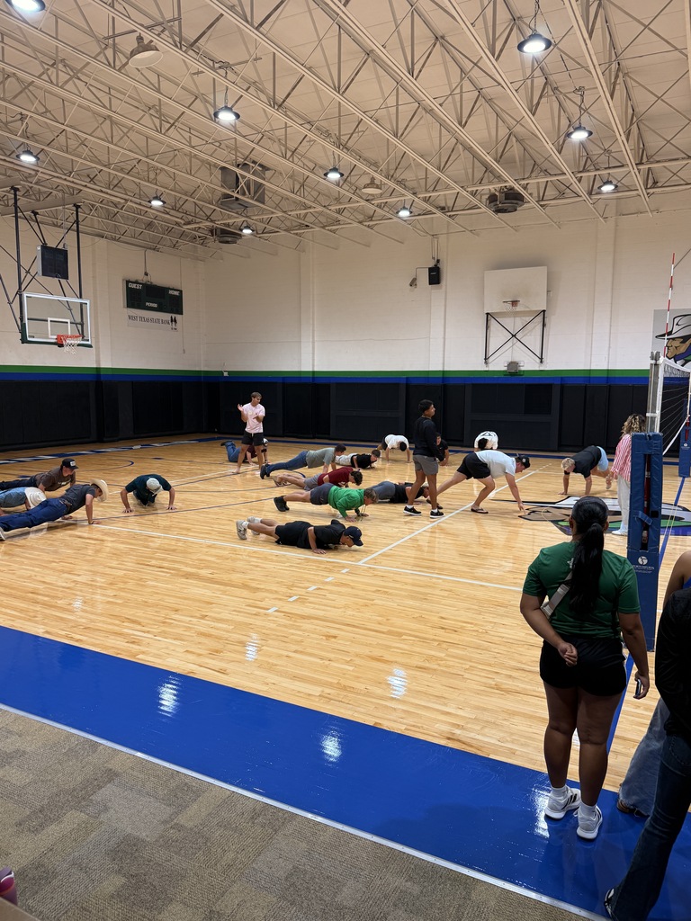 Students complete a physical team activity together on the WTC gym floor.