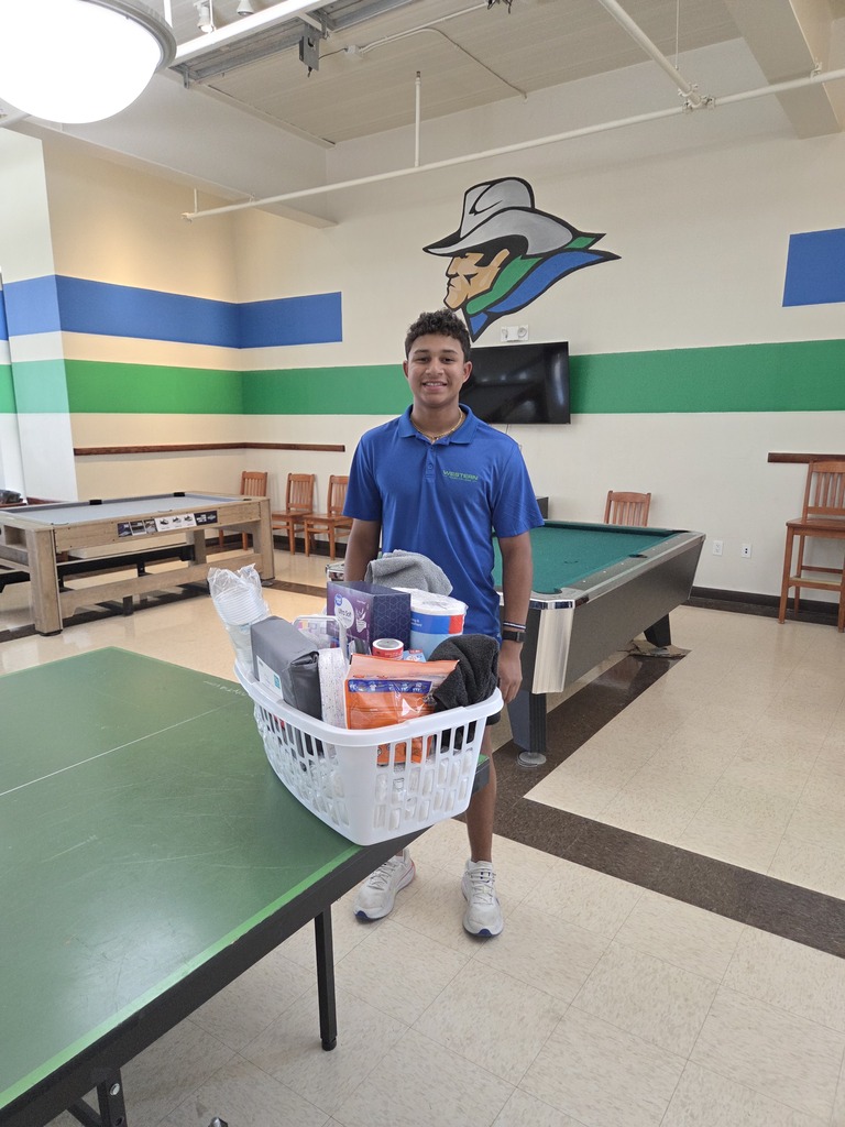 WTC student stands behind a prize basket inside the Student Commons.