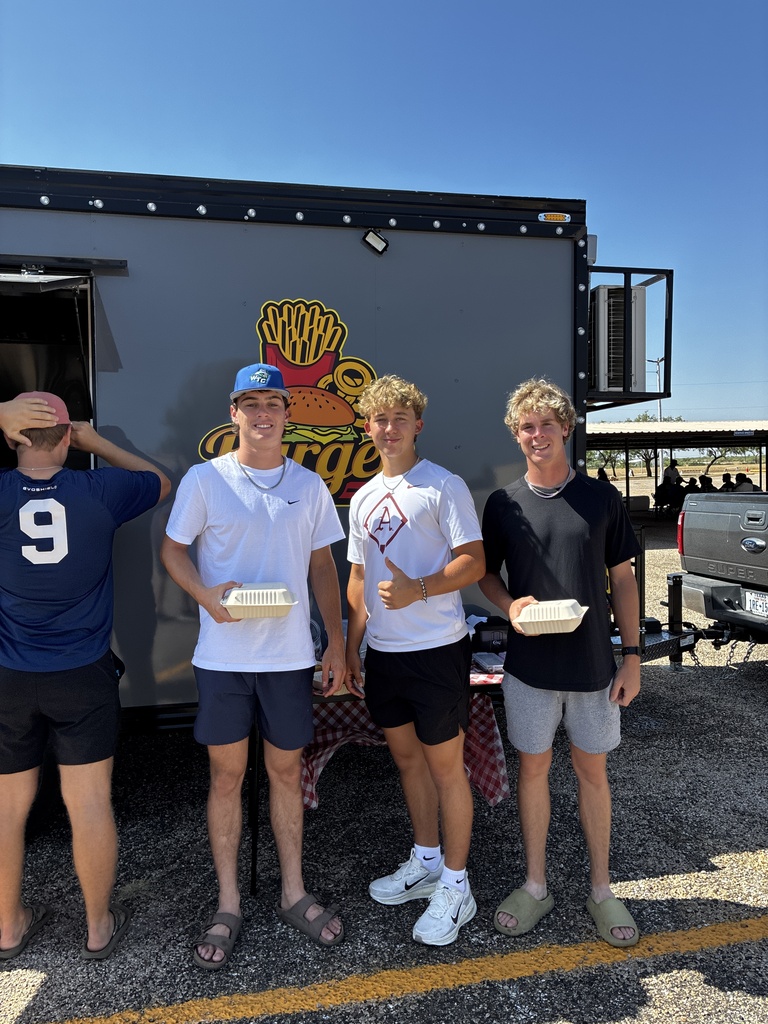 Three WTC students pose with meals in front of a food truck during Westerner Welcome Day.