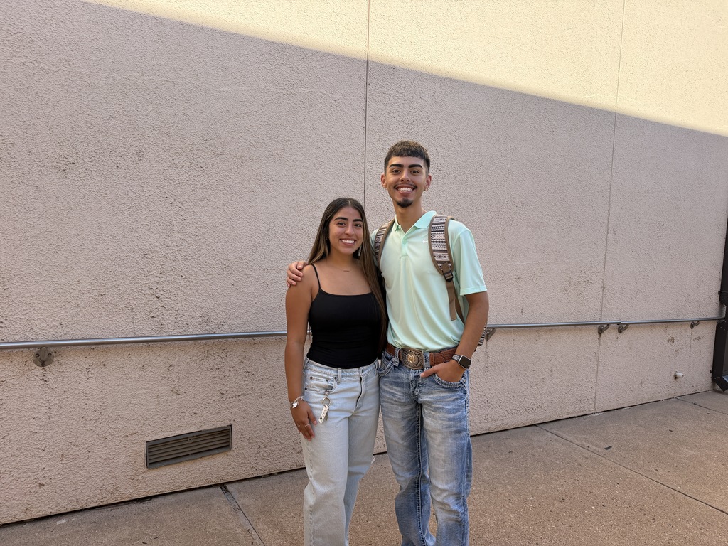 Two WTC students smile together outside on campus.