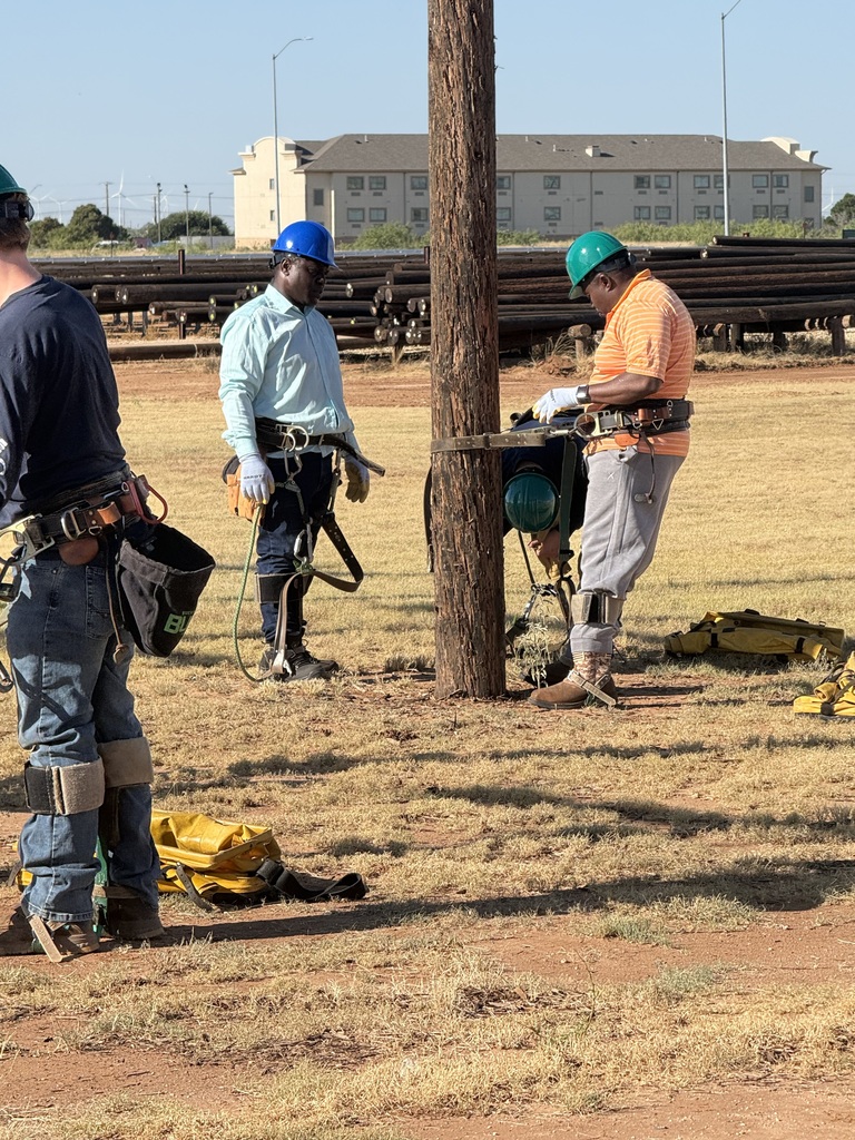 Electrical Lineworker Technology students prepare climbing equipment beside a utility pole during hands-on training at WTC.
