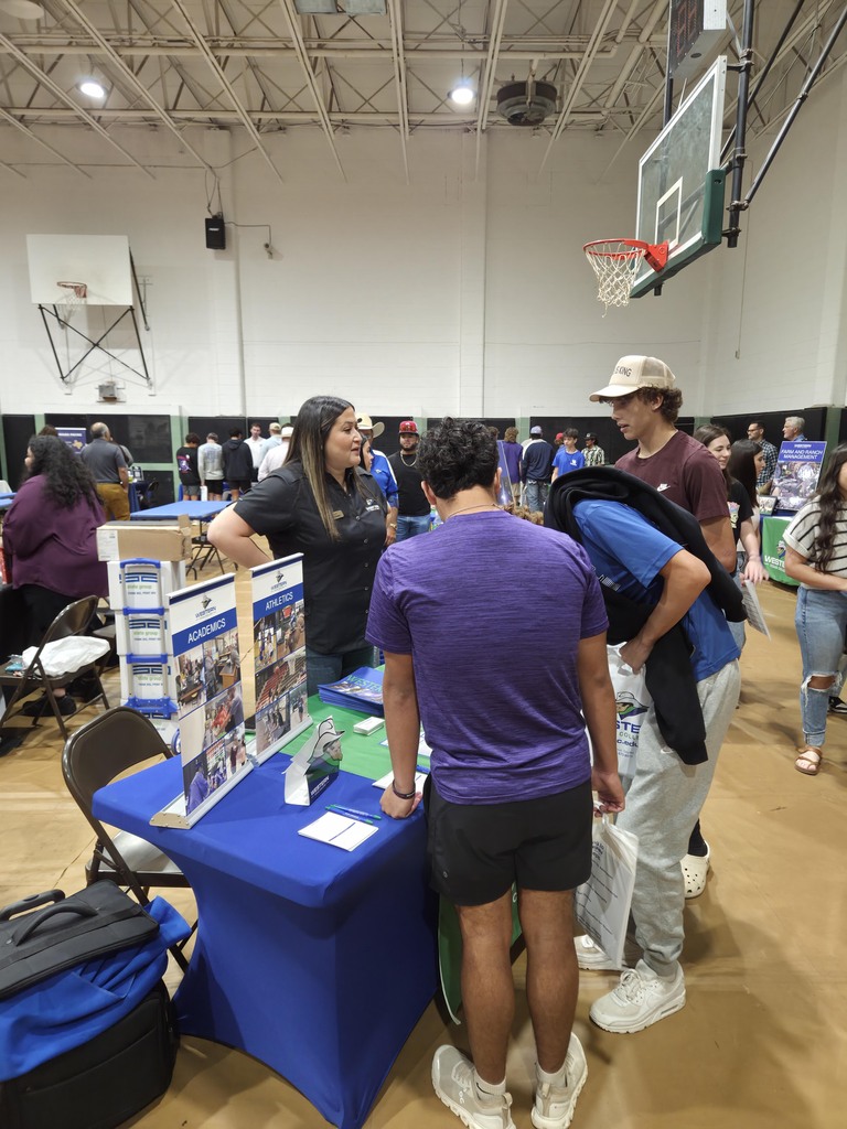 Prospective students speak with a Western Texas College representative at a college fair.