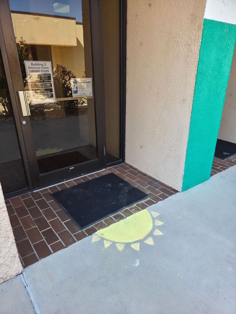 A yellow chalk sun decorates the sidewalk outside the Western Texas College Resource Center.