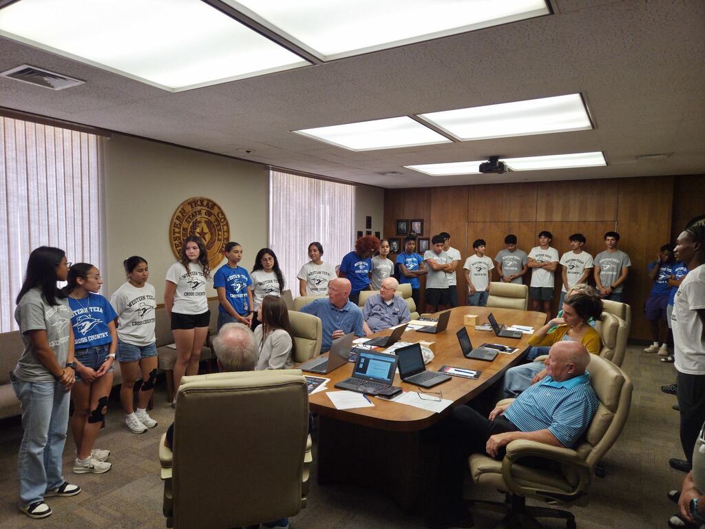 WTC cross country and track student-athletes stand before the Board of Trustees during a campus meeting.