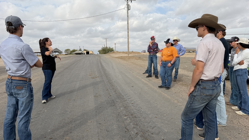 A dairy farm representative speaks to Western Texas College students during an outdoor tour of the farm.