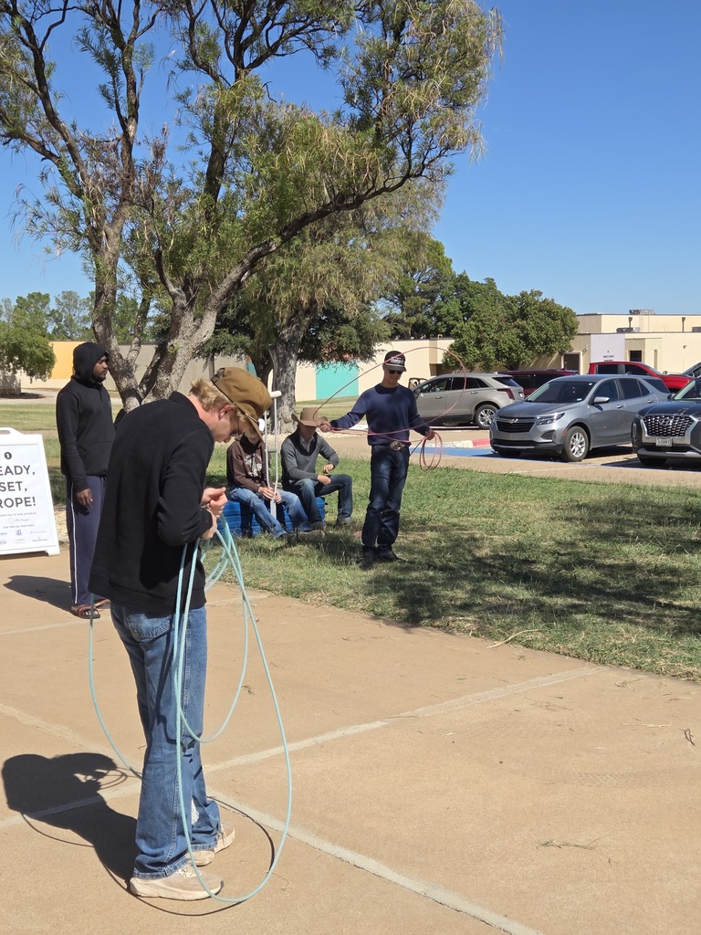 Young men practicing roping next to the flagpoles.