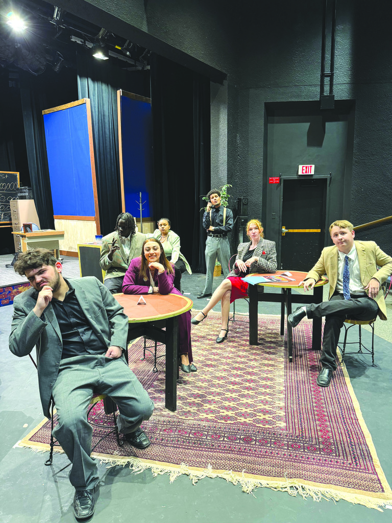 The cast poses on stage.