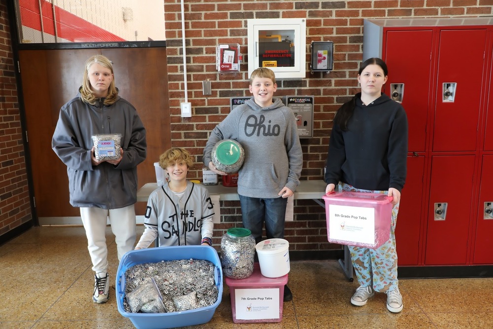 Students posing with pop tab donations