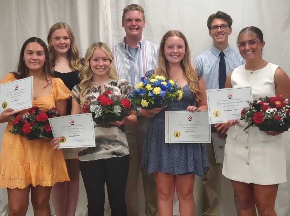 Students holding certificates and flowers
