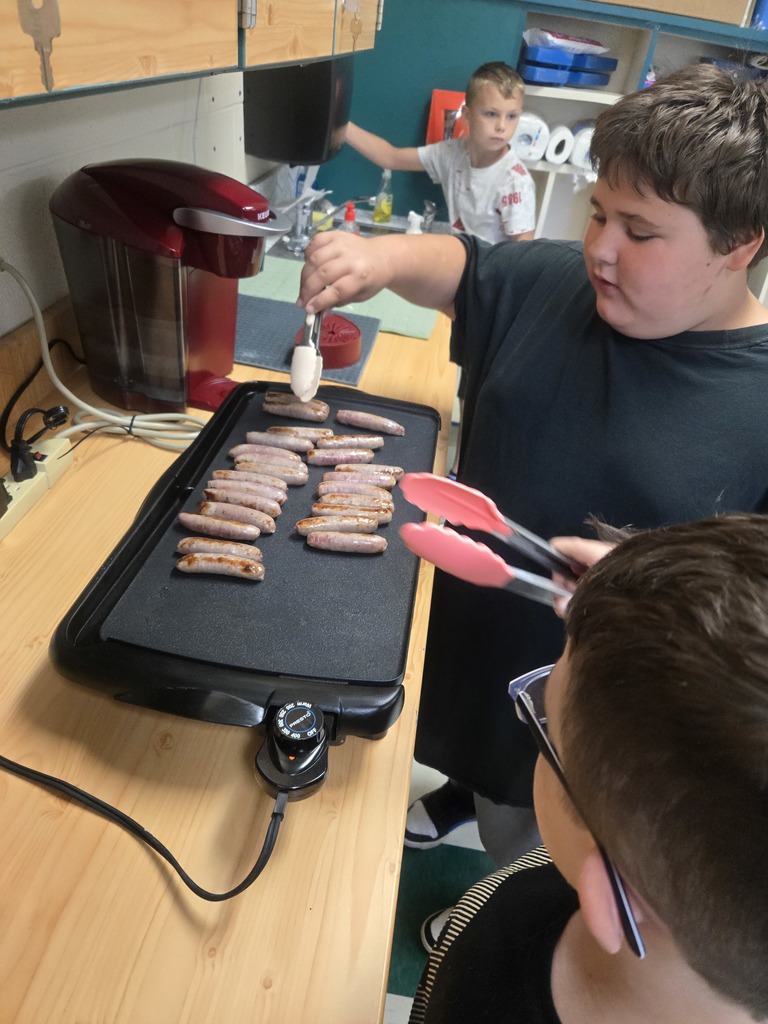 Students cooking sausages