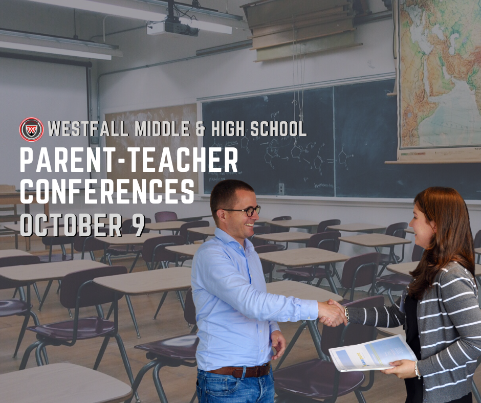 Man and woman shaking hands in front of an empty classroom full of desks
