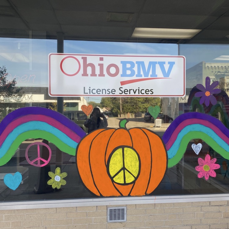 painted window with pumpkin and peace sign