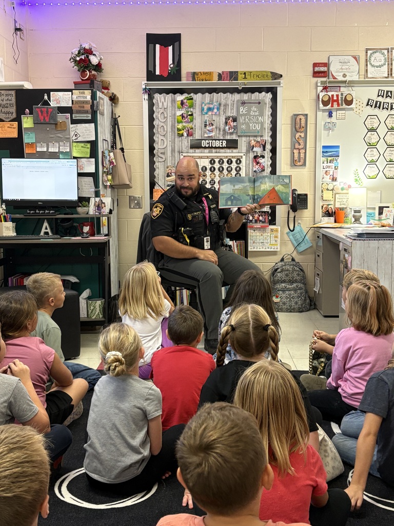 Deputy Freeman reading a book to a group of students