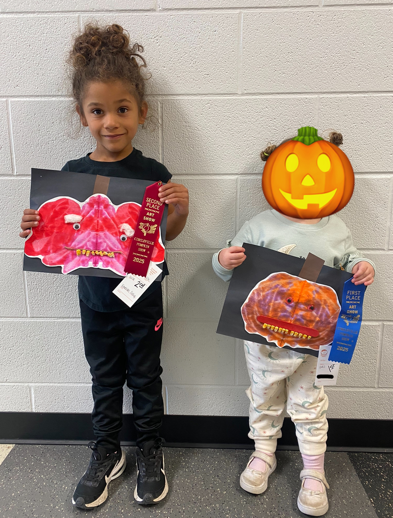 Preschool Student holding prize winning pumpkin artwork 