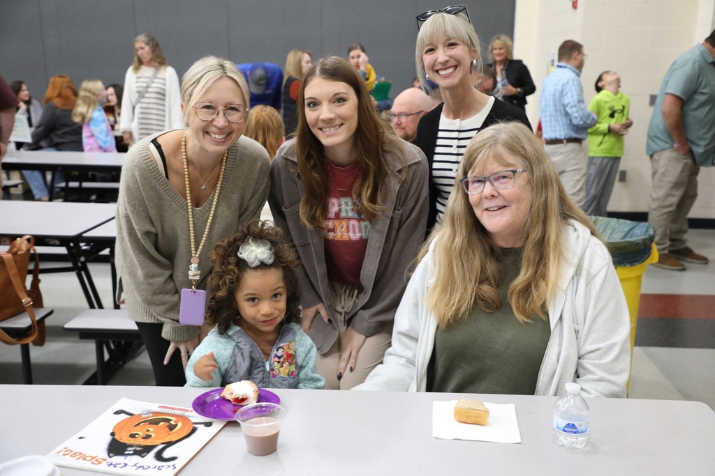 Students with teacher and family in cafeteria