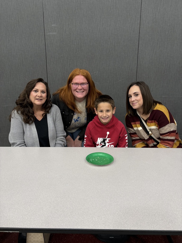 Students with teacher and family in cafeteria