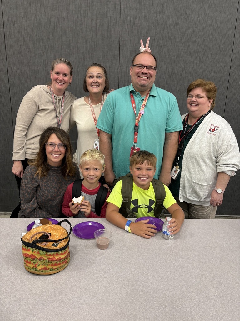 Students with teacher and family in cafeteria