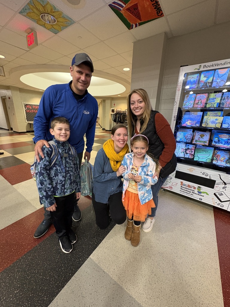 Students with teacher and family in cafeteria