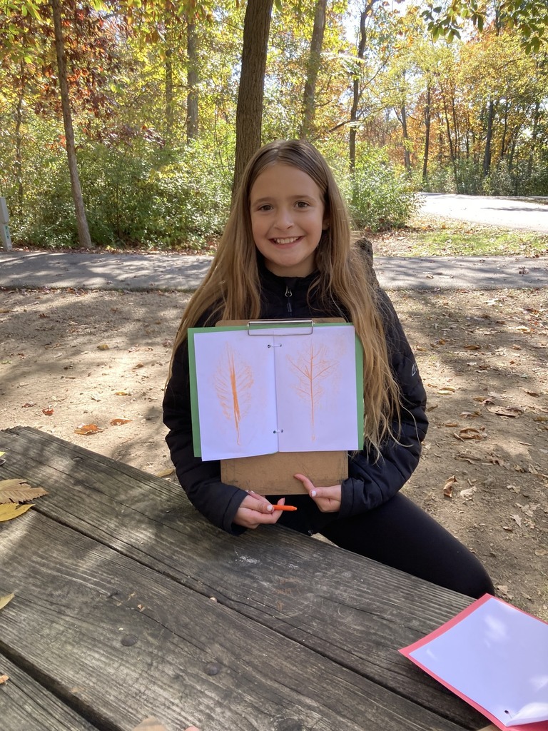Student holding up leaf rubbing