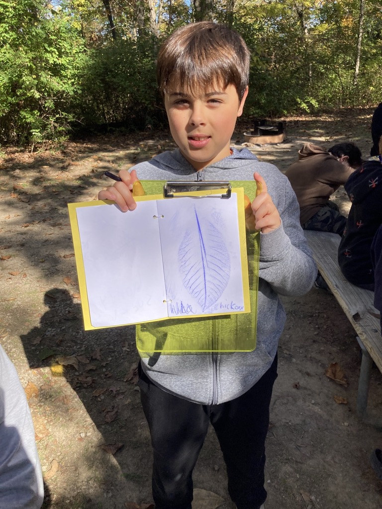 Student holding up leaf rubbing
